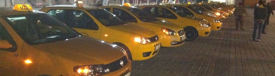 Gece, ofisin önünde farları yanan taksi filosu