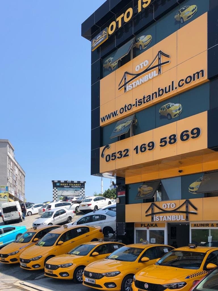 Oto İstanbul tabelası ve telefon numarası, önünde sarı taksiler